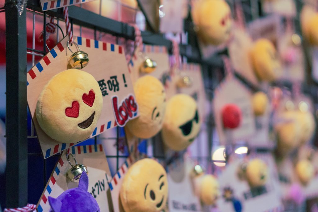 Llaveros con forma de emojis colgados en un muro